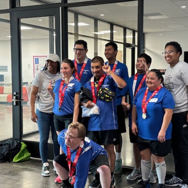 Special Olympics Basketball team receiving a gold medal for their efforts