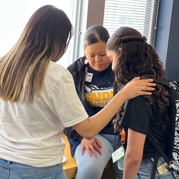 Teachers at Eastwood Middle School praying with a student who requested prayer.