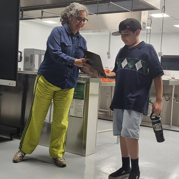 Moving making month: Participant receiving his badge/magnet and certificate of completion by a community member of El Paso fighting hunger. 