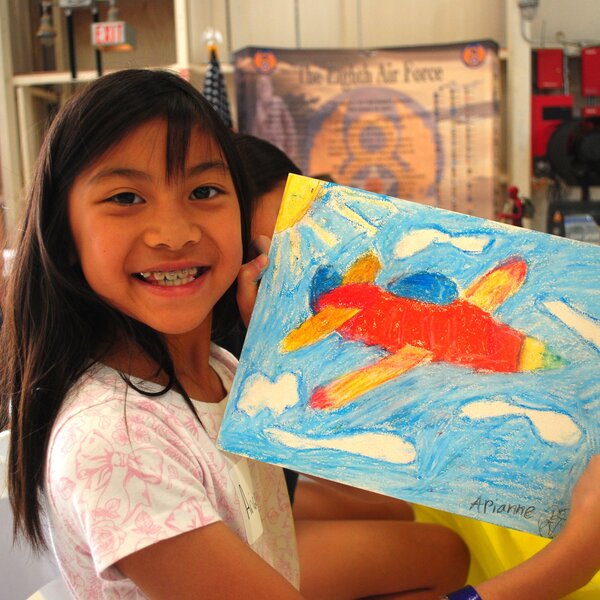 Girl learns how to draw an airplane during our War Eagles artmaker Camp