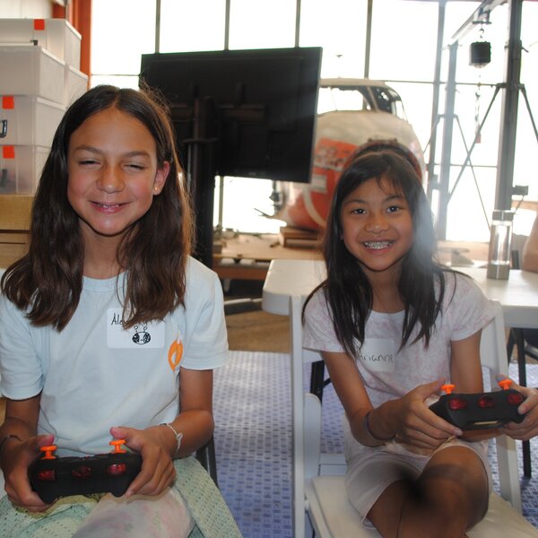 Children from the YWCA learn how to fly a drone at the war Eagles Museum