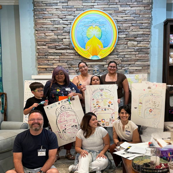 CGC Staff, Volunteers, and families pose with their artwork during our Grief & Back to School specialty group this past July
